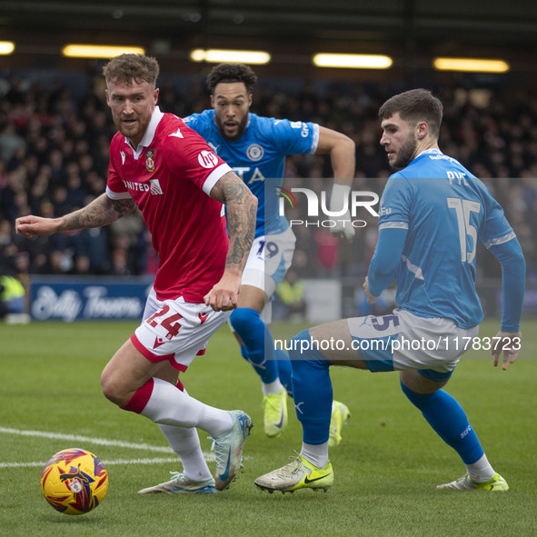 Dan Scarr #24 of Wrexham A.F.C. is challenged by Ethan Pye #15 of Stockport County F.C. during the Sky Bet League 1 match between Stockport...