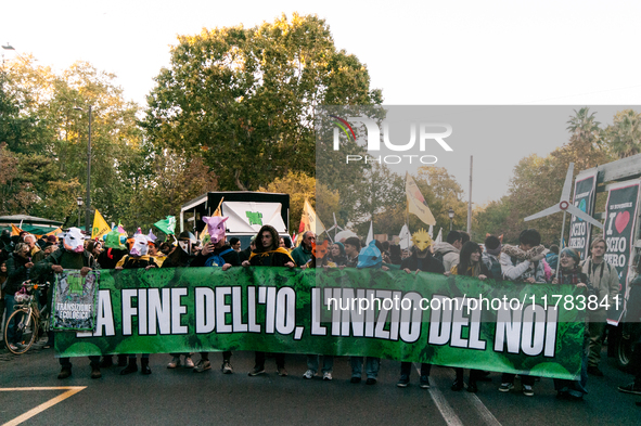 People wear animal masks and hold signs and banners as they participate in the street parade for the Climate Pride on November 16, 2024 in R...