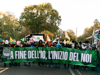 People wear animal masks and hold signs and banners as they participate in the street parade for the Climate Pride on November 16, 2024 in R...