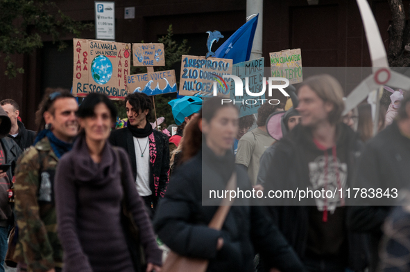 People wear animal masks and hold signs and banners as they participate in the street parade for the Climate Pride on November 16, 2024 in R...