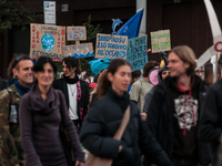 People wear animal masks and hold signs and banners as they participate in the street parade for the Climate Pride on November 16, 2024 in R...