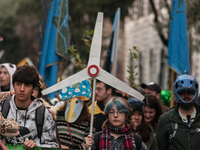 People wear animal masks and hold signs and banners as they participate in the street parade for the Climate Pride on November 16, 2024 in R...