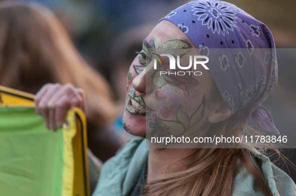 People wear animal masks and hold signs and banners as they participate in the street parade for the Climate Pride on November 16, 2024 in R...