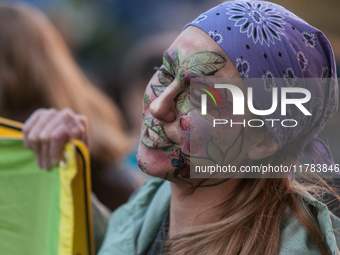 People wear animal masks and hold signs and banners as they participate in the street parade for the Climate Pride on November 16, 2024 in R...