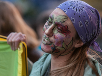 People wear animal masks and hold signs and banners as they participate in the street parade for the Climate Pride on November 16, 2024 in R...