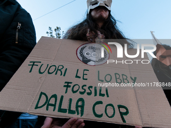 People wear animal masks and hold signs and banners as they participate in the street parade for the Climate Pride on November 16, 2024 in R...