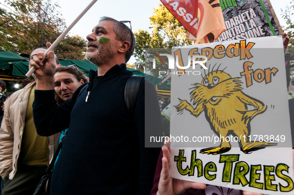 People wear animal masks and hold signs and banners as they participate in the street parade for the Climate Pride on November 16, 2024 in R...