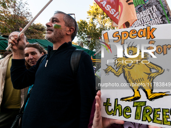 People wear animal masks and hold signs and banners as they participate in the street parade for the Climate Pride on November 16, 2024 in R...