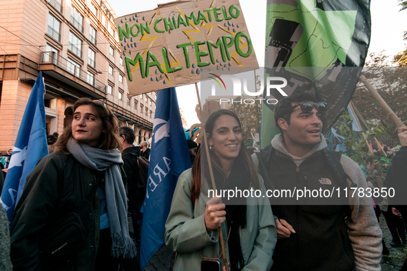 People wear animal masks and hold signs and banners as they participate in the street parade for the Climate Pride on November 16, 2024 in R...