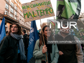 People wear animal masks and hold signs and banners as they participate in the street parade for the Climate Pride on November 16, 2024 in R...