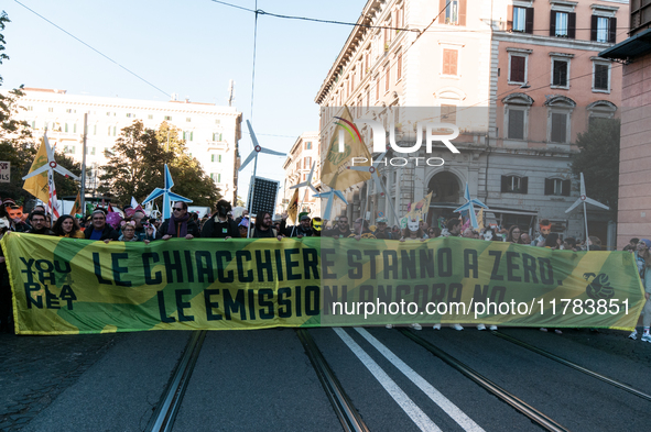 People wear animal masks and hold signs and banners as they participate in the street parade for the Climate Pride on November 16, 2024 in R...