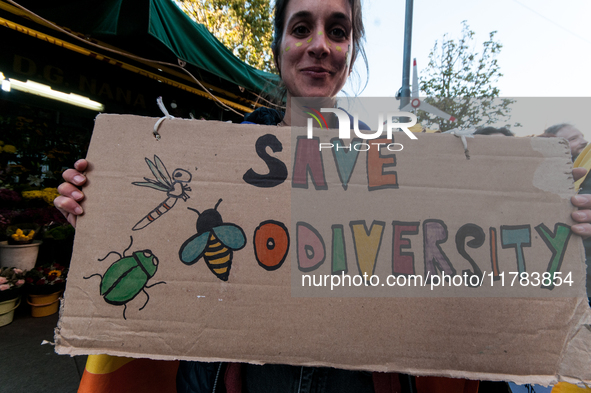 People wear animal masks and hold signs and banners as they participate in the street parade for the Climate Pride on November 16, 2024 in R...