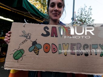 People wear animal masks and hold signs and banners as they participate in the street parade for the Climate Pride on November 16, 2024 in R...