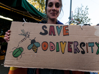 People wear animal masks and hold signs and banners as they participate in the street parade for the Climate Pride on November 16, 2024 in R...