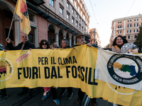 People wear animal masks and hold signs and banners as they participate in the street parade for the Climate Pride on November 16, 2024 in R...