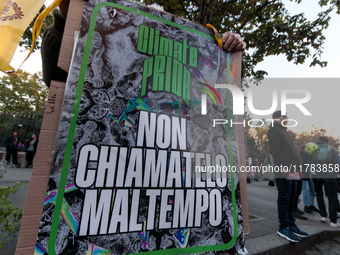 People wear animal masks and hold signs and banners as they participate in the street parade for the Climate Pride on November 16, 2024 in R...