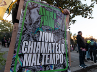 People wear animal masks and hold signs and banners as they participate in the street parade for the Climate Pride on November 16, 2024 in R...