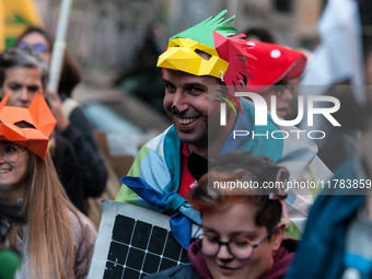 People wear animal masks and hold signs and banners as they participate in the street parade for the Climate Pride on November 16, 2024 in R...