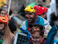 People wear animal masks and hold signs and banners as they participate in the street parade for the Climate Pride on November 16, 2024 in R...