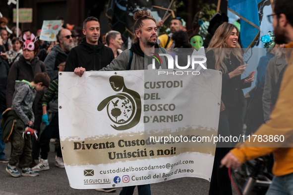 People wear animal masks and hold signs and banners as they participate in the street parade for the Climate Pride on November 16, 2024 in R...