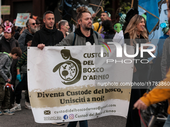 People wear animal masks and hold signs and banners as they participate in the street parade for the Climate Pride on November 16, 2024 in R...