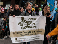 People wear animal masks and hold signs and banners as they participate in the street parade for the Climate Pride on November 16, 2024 in R...