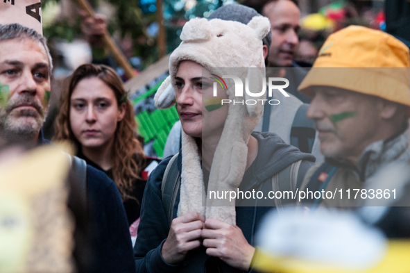 People wear animal masks and hold signs and banners as they participate in the street parade for the Climate Pride on November 16, 2024 in R...