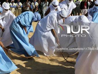 The photo, taken in Oued Souf, Algeria, on November 16, 2024, shows young Sahrawis playing a traditional game called taketchit during the In...