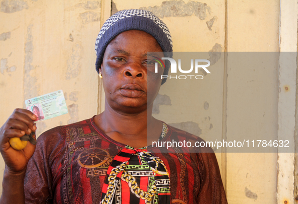 Mary Demehin shows her voter's card after voting during the 2024 Governorship election for Ondo State in Obenla, Ilaje, Local Government Are...