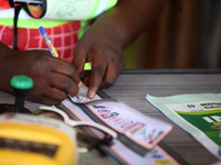 An INEC official signs a ballot paper during the 2024 Governorship election for Ondo State in Obenla, Ilaje, Local Government Area, Ondo Sta...