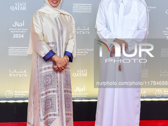 Fatma Al Remaihi, CEO of the Doha Film Institute, and Abdulla Yousef Al Mulla attend the ''Sudan, Remember Us'' red carpet during the screen...