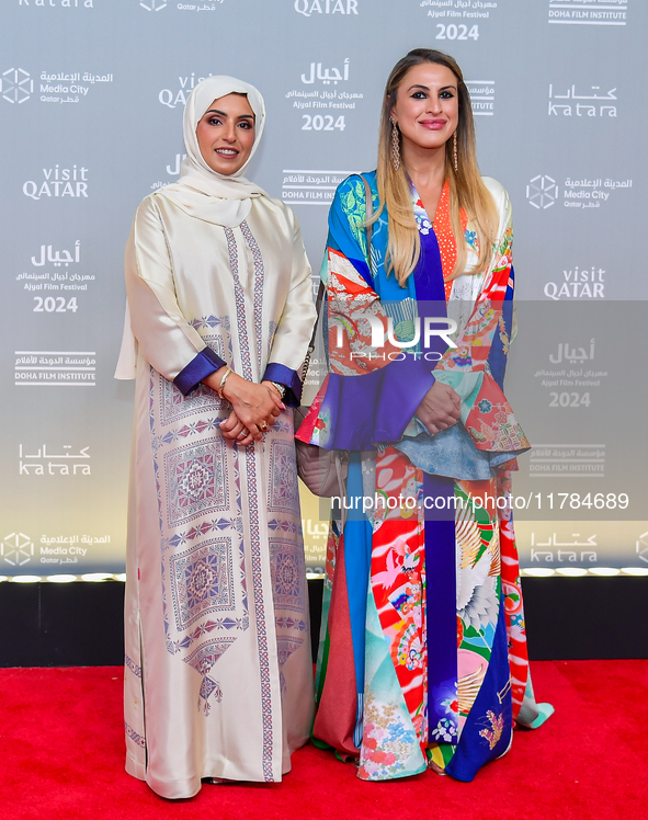 Fatma Al Remaihi, CEO of the Doha Film Institute, poses with a guest on the red carpet during the ''Sudan, Remember Us'' screening on the op...