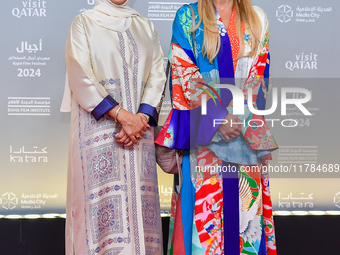 Fatma Al Remaihi, CEO of the Doha Film Institute, poses with a guest on the red carpet during the ''Sudan, Remember Us'' screening on the op...