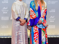 Fatma Al Remaihi, CEO of the Doha Film Institute, poses with a guest on the red carpet during the ''Sudan, Remember Us'' screening on the op...