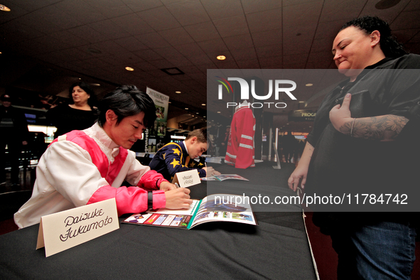 Jockeys Daisuke Fukumoto, left, and Fraser Aebly sign autographs to help raise funds for LongRun Thoroughbred Retirement Society, an organiz...