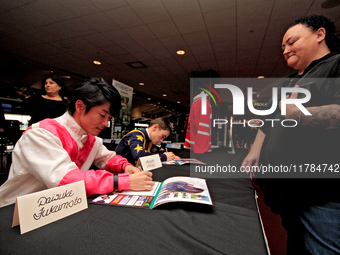 Jockeys Daisuke Fukumoto, left, and Fraser Aebly sign autographs to help raise funds for LongRun Thoroughbred Retirement Society, an organiz...