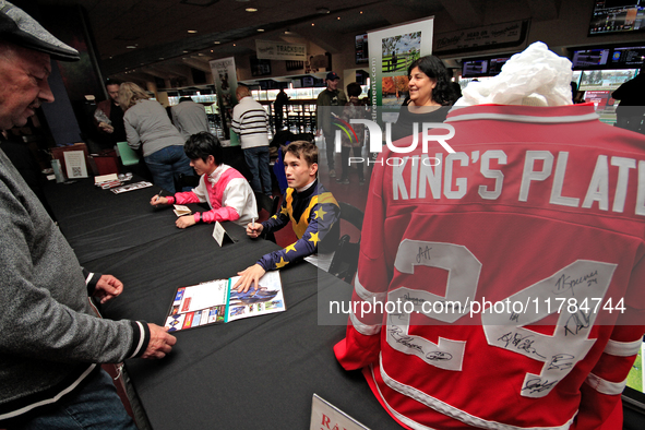 Jockeys Daisuke Fukumoto, left, and Fraser Aebly sign autographs to help raise funds for LongRun Thoroughbred Retirement Society, an organiz...