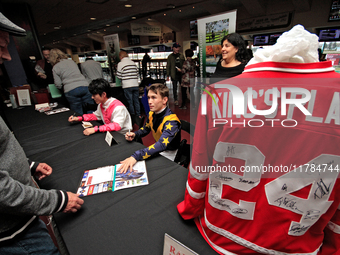 Jockeys Daisuke Fukumoto, left, and Fraser Aebly sign autographs to help raise funds for LongRun Thoroughbred Retirement Society, an organiz...