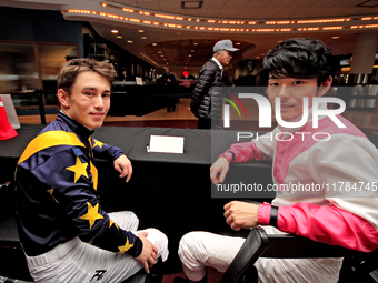 Jockeys Fraser Aebly, left, and Daisuke Fukumoto sign autographs to help raise funds for LongRun Thoroughbred Retirement Society, an organiz...