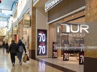 Promotional signage advertises up to 70% off for Black Friday at a clothing store in Molfetta, Italy, on November 17, 2024. The image highli...