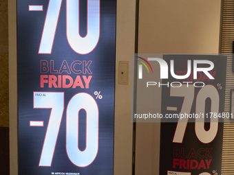 Promotional signage advertises up to 70% off for Black Friday at a clothing store in Molfetta, Italy, on November 17, 2024. The image highli...