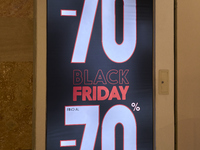 Promotional signage advertises up to 70% off for Black Friday at a clothing store in Molfetta, Italy, on November 17, 2024. The image highli...