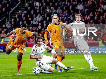 Netherlands defender Denzel Dumfries, Hungary midfielder Tamas Nikitscher, and Netherlands defender Virgil van Dijk participate in the match...