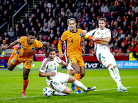 Netherlands defender Denzel Dumfries, Hungary midfielder Tamas Nikitscher, and Netherlands defender Virgil van Dijk participate in the match...