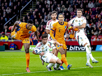 Netherlands defender Denzel Dumfries, Hungary midfielder Tamas Nikitscher, and Netherlands defender Virgil van Dijk participate in the match...