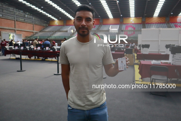 A person shows his new permanent driver's license after applying for it at the processing point installed in the Ciudad Deportiva, in the Iz...