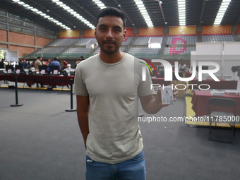 A person shows his new permanent driver's license after applying for it at the processing point installed in the Ciudad Deportiva, in the Iz...