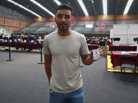 A person shows his new permanent driver's license after applying for it at the processing point installed in the Ciudad Deportiva, in the Iz...