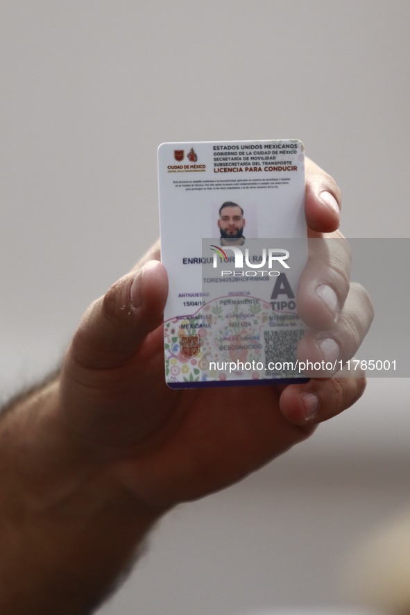 A person shows his new permanent driver's license after applying for it at the processing point installed in the Ciudad Deportiva, in the Iz...