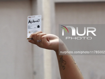 A person shows his new permanent driver's license after applying for it at the processing point installed in the Ciudad Deportiva, in the Iz...